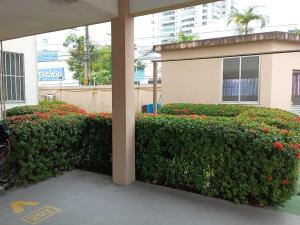 a hedge in front of a building with flowers at GUARÁS - Complete & excellent locationCOP 30 in Belém