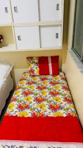 a bed in a room with a flower patterned blanket at GUARÁS - Complete & excellent locationCOP 30 in Belém