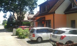 two cars parked in a parking lot next to a building at Petra Vendégház in Bük