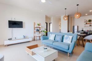 a living room with a blue couch and a table at Casa Chavela10 Min Beach, Wifi 500 Mb, Gym, Pools in Playa del Carmen