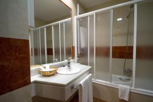 a bathroom with a sink and a shower and a mirror at Hotel Los 5 Pinos in Madrid +30 photos