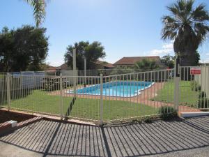 a fence in front of a swimming pool at Ocean View Villas in Geraldton