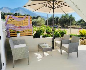 a patio with an umbrella and chairs and a table at Villa Margarita in Kyparissia