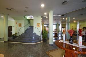 a lobby with a staircase with blue stairs and a table at Hotel Los 5 Pinos in Madrid