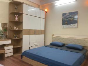 a bedroom with a bed with blue pillows in it at Ribi Home in Hà Ðông