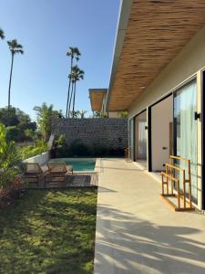 a backyard with a pool and a house at Julim Aura - Best Agung View in Amed