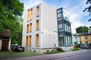 a white building with orange windows on a street at Villa 21 by Victus in Sopot