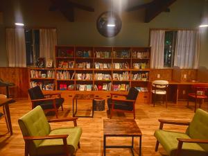 a library with chairs and book shelves with books at 宿と図書サロン 花車 Hanagurum Inn in Amakusa +46 photos