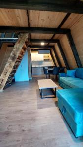 a living room with a blue couch and a table at Vila Alpine Arlon Gjinar in Gjinar