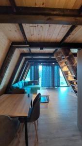 a large room with wooden ceilings and tables and chairs at Vila Alpine Arlon Gjinar in Gjinar