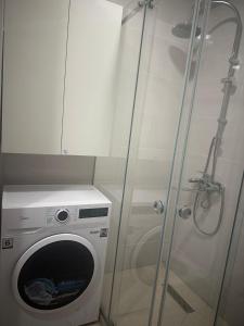 y baño con ducha y lavadora. en сдается квартира, en Tiflis