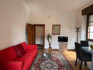 Una sala de estar con un sofá rojo y una mesa. en Appartamento Porretta Sweet Soul, en Porretta Terme