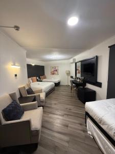 a hotel room with two beds and a flat screen tv at Bankstown Motel 10 in Bankstown