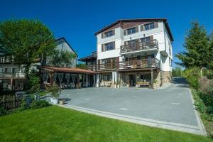 a large white building with a large driveway at Dom Wiejska 39 a in Ruciane-Nida