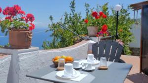 a table with a bowl of fruit on a balcony with flowers at Casa Via del Mare in Taormina