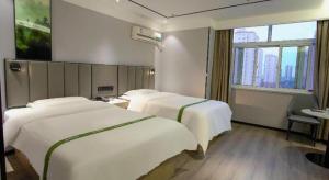 Voodi või voodid majutusasutuse GreenTree Inn LiaoCheng LinQing HaiShan Building Express Hotel toas