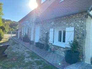 a stone house with a window and potted plants at Pause Campagne 1 