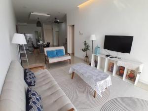 a living room with a couch and a flat screen tv at Condominium Crystal Heights in Taiping