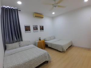 a room with two beds and a couch and a table at Condominium Crystal Heights in Taiping
