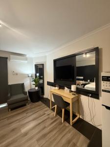 a living room with a large television and a desk at Bankstown Motel 10 in Bankstown
