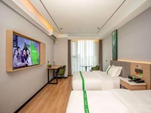 a hotel room with two beds and a flat screen tv at GreenTree Inn Bengbu Huaihe Walking Street in Bengbu