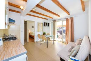 a kitchen and living room with a couch and a table at Apartments Cala in Biograd na Moru