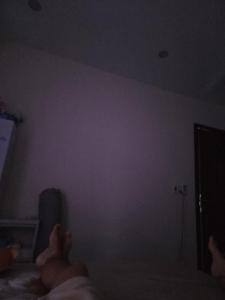 a person laying on a bed watching a tv at Back ally beach house in Dong Hoi