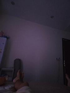 a person laying on a bed in a dark room at Back ally beach house in Dong Hoi
