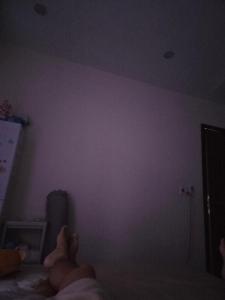 a person laying on a bed in a dark room at Back ally beach house in Dong Hoi
