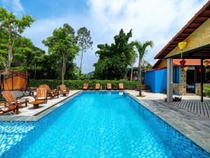 a swimming pool with lounge chairs next to a house at Cozy Son Hotel in Ninh Binh