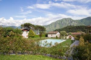a villa with a pool and mountains in the background at Appartamenti Zerboni in Lenno