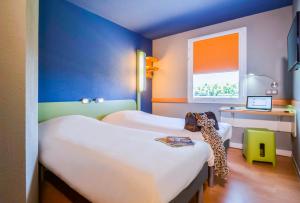 um quarto com duas camas e uma janela em Ibis Budget Porte de Camargue em Saint-Martin-de-Crau