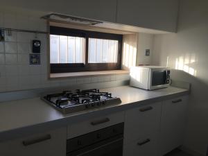 uma cozinha com um fogão e um micro-ondas em Attico Fronte Mare em Pozzallo