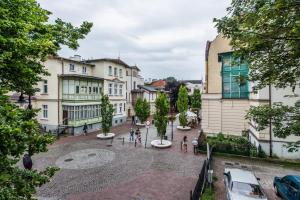 un grupo de personas caminando por una calle con edificios en Top Booking - New, en Sopot