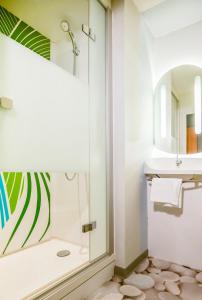 a bathroom with a shower and a sink at Ibis Budget Porte de Camargue in Saint-Martin-de-Crau +51 photos