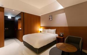 IksanTop Cloud Hotel Iksan的一间带床和椅子的酒店房间