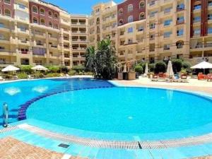 a large swimming pool in front of a large apartment building at كمباوند فلورينزا 50 in Hurghada