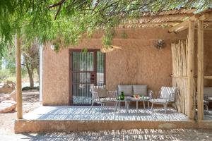a patio with a table and chairs in front of a house at Lotan Desert Travel Hotel in Kibbutz Lotan