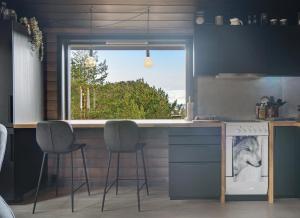 eine Küche mit einer Theke mit Stühlen und einem Fenster in der Unterkunft Mortenhytta, Valevåg in Valevåg + 12 Fotos