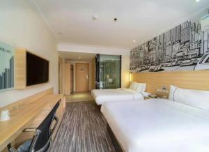 a hotel room with two beds and a flat screen tv at City Comfort Inn Huangshi City Huangshi Avenue in Huangshi +169 photos