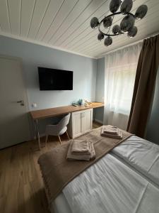 a bedroom with a bed and a desk and a television at Dom nad Lubiążem in Lubniewice