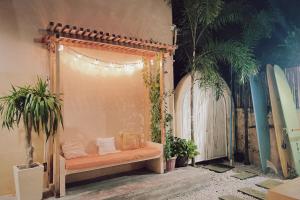 a bench in a room with palm trees and surfboards at Meraki Siargao Resort in General Luna