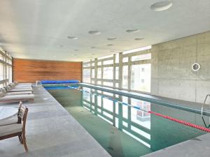 a swimming pool in a building with benches and chairs at Cute Condesa Studio Indoor Pool Nice Gym in Mexico City