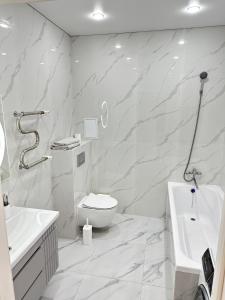 a white bathroom with a toilet and a sink at ПОЛНОЦЕННАЯ ТРЕХКОМНАТНаЯ ЛЮКС in Kokshetau +11 photos