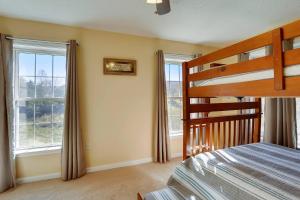 a bedroom with a bunk bed and two windows at Close To Dt Asheville, Hot Tub, Pool Table in Weaverville