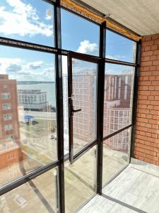 a room with windows with a view of a city at ПОЛНОЦЕННАЯ ТРЕХКОМНАТНаЯ ЛЮКС in Kokshetau