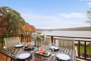 a table on a deck with a view of a lake at Lake Front, Ski,hot Tub, Fire Pit, Fp, Boats in Gouldsboro