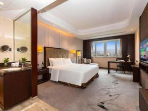 a bedroom with a large white bed and a television at Mianzhu Minshan Hotel in Deyang +275 photos