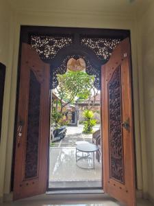 eine offene Tür zu einer Terrasse mit einem Tisch in der Unterkunft Stellar Cottage Lovina- a villa in Murni's house in Lovina + 10 Fotos