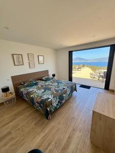 a bedroom with a bed and a large window at Villa de Luxe avec Piscine à débordement chauffée à Porticcio in Porticcio
